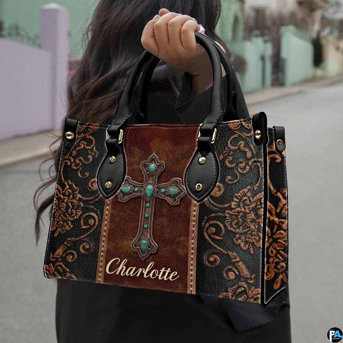 Front view of western turquoise cross handbag showcasing central bronze medallion and scroll detailing.
