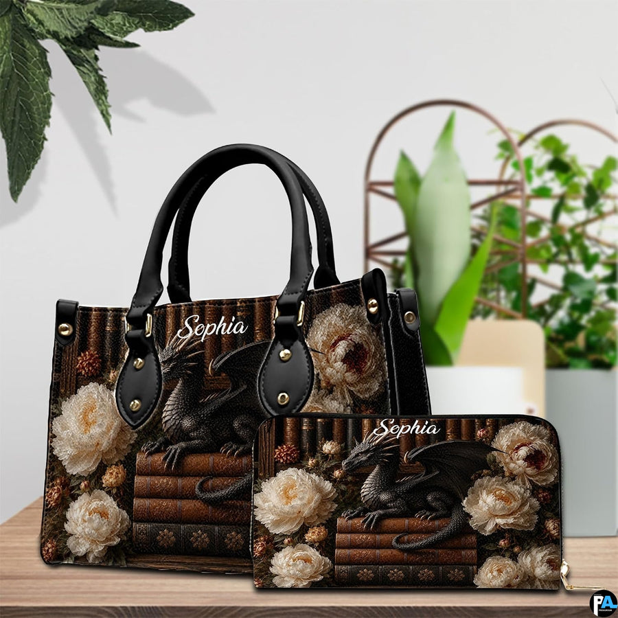 Three-quarter view of black dragon purse showing structured shape, handles, and gold hardware