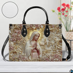 Angled view of sculpted alabaster mary handbag and wallet set showing coordinating devotional relief artwork.