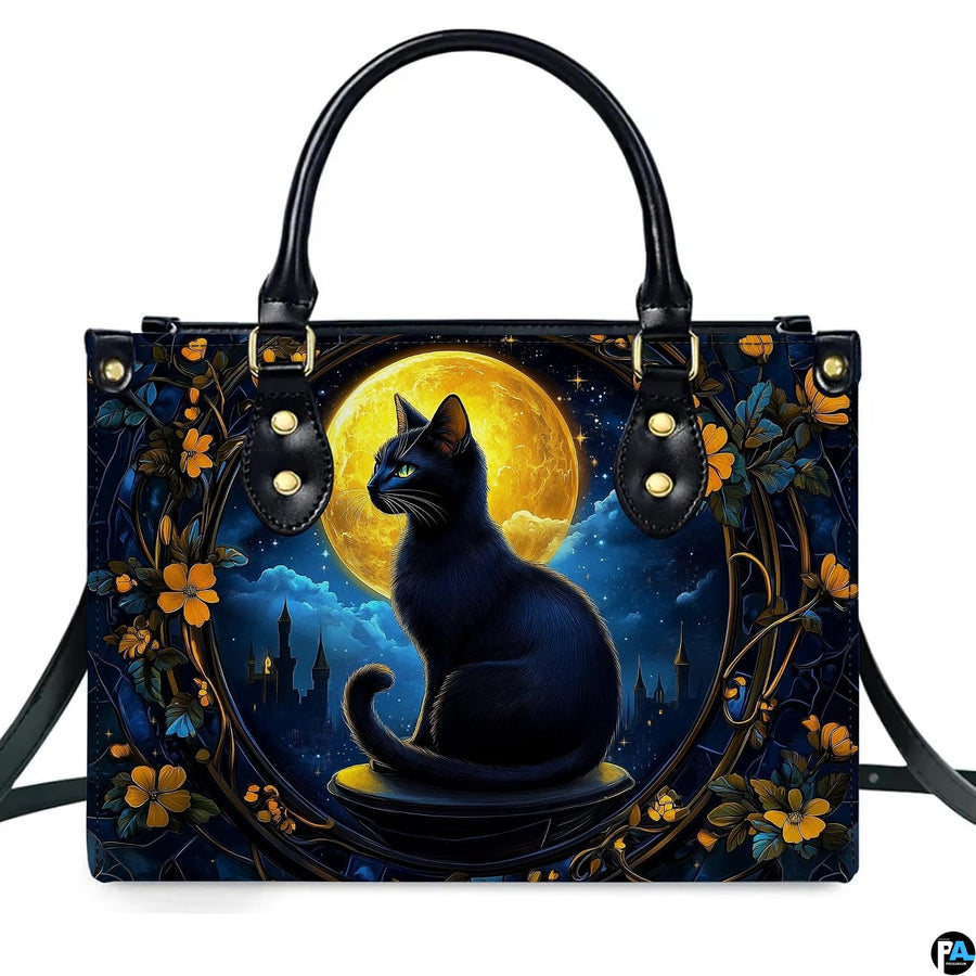 Front studio view showing black cat seated before glowing golden harvest moon in gothic floral frame.