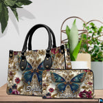Close-up front view of handbag showing teal butterfly and gold scrollwork