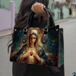 Handbag with radiant Immaculate Heart of Mary portrait held outdoors on city walkway.