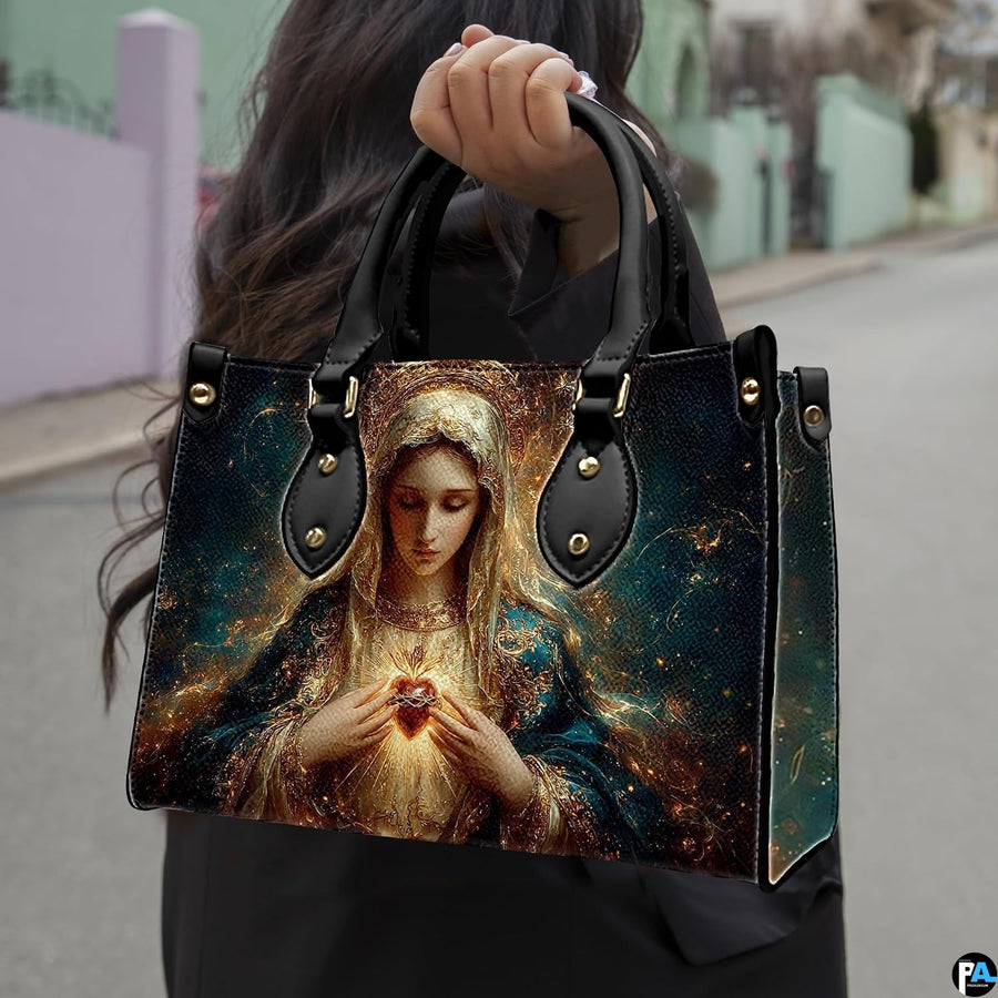 Handbag with radiant Immaculate Heart of Mary portrait held outdoors on city walkway.