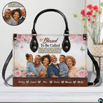 Side profile view of structured floral handbag showing sleek silhouette and black carrying handles.