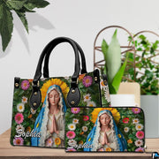 Virgin Mary floral handbag and coordinated wallet set displayed on wooden surface