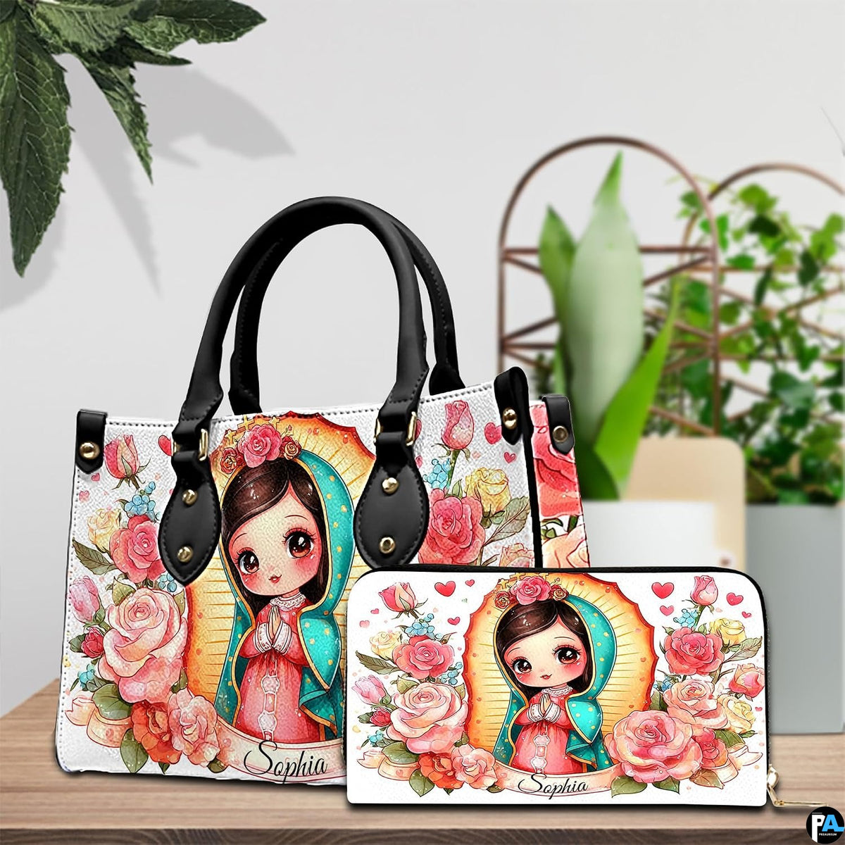 Chibi Guadalupe handbag and coordinating wallet displayed on a wooden table beside potted plants.
