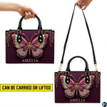 Bottom view of plum butterfly handbag showing flat rectangular base
