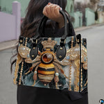 Front view of jeweled bee handbag showing golden crown and deep emerald marble pattern.