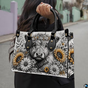 Outdoor street view of monochrome sketch Highland cow floral design carried by hand