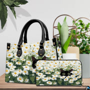 Tabletop presentation showing peeking black cat art on wood beside green houseplants.
