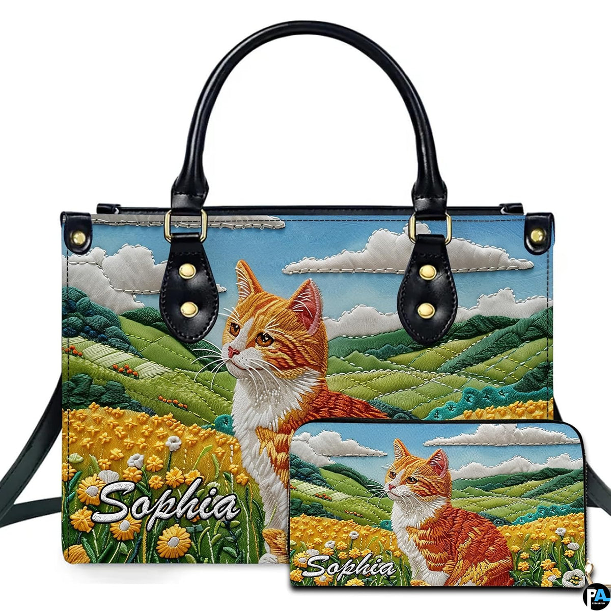 Embroidered ginger tabby cat seated in a yellow buttercup meadow beside rolling green hills.