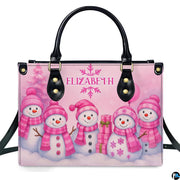 Front view of structured handbag featuring five smiling snowmen in pink knitwear with holiday gifts.