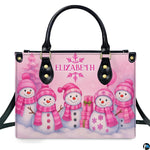 Front view of structured handbag featuring five smiling snowmen in pink knitwear with holiday gifts.