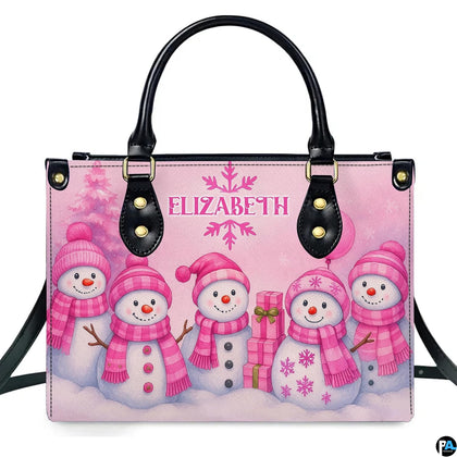 Front view of structured handbag featuring five smiling snowmen in pink knitwear with holiday gifts.