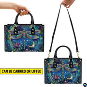 Top view of celestial dragonfly handbag showing zippered top closure and dual structured handles