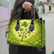 Model carrying clover tree handbag with glowing cream and emerald artwork