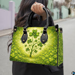 Model carrying clover tree handbag with glowing cream and emerald artwork