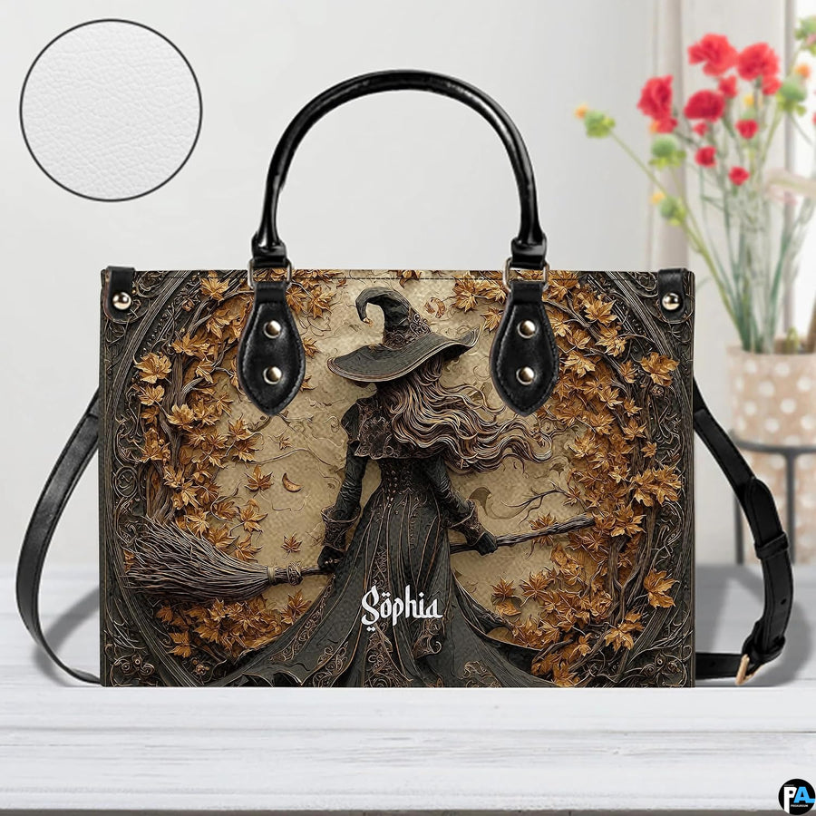 Gothic autumn witch handbag displayed on white table beside floral bouquet.