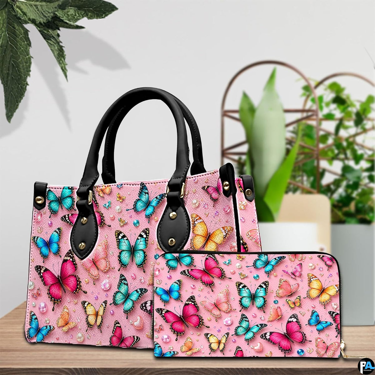 Lifestyle tabletop presentation showing colorful butterfly artwork placed beside lush indoor house plants.