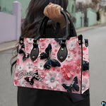 Front close-up view of handbag showing black butterfly and daisies