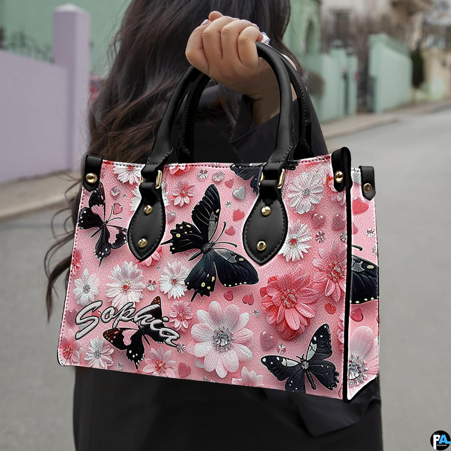 Front close-up view of handbag showing black butterfly and daisies