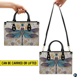 Angle perspective view of the dragonfly handbag displaying side depth and printed pattern.