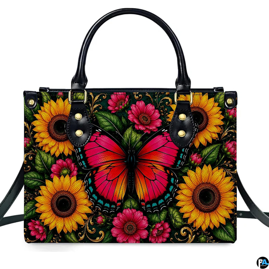 Direct front studio view showcasing the pink monarch butterfly and blooming golden sunflowers on white surface.
