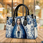 Devotional Virgin Mary ceramic tile handbag presented on wooden tabletop.