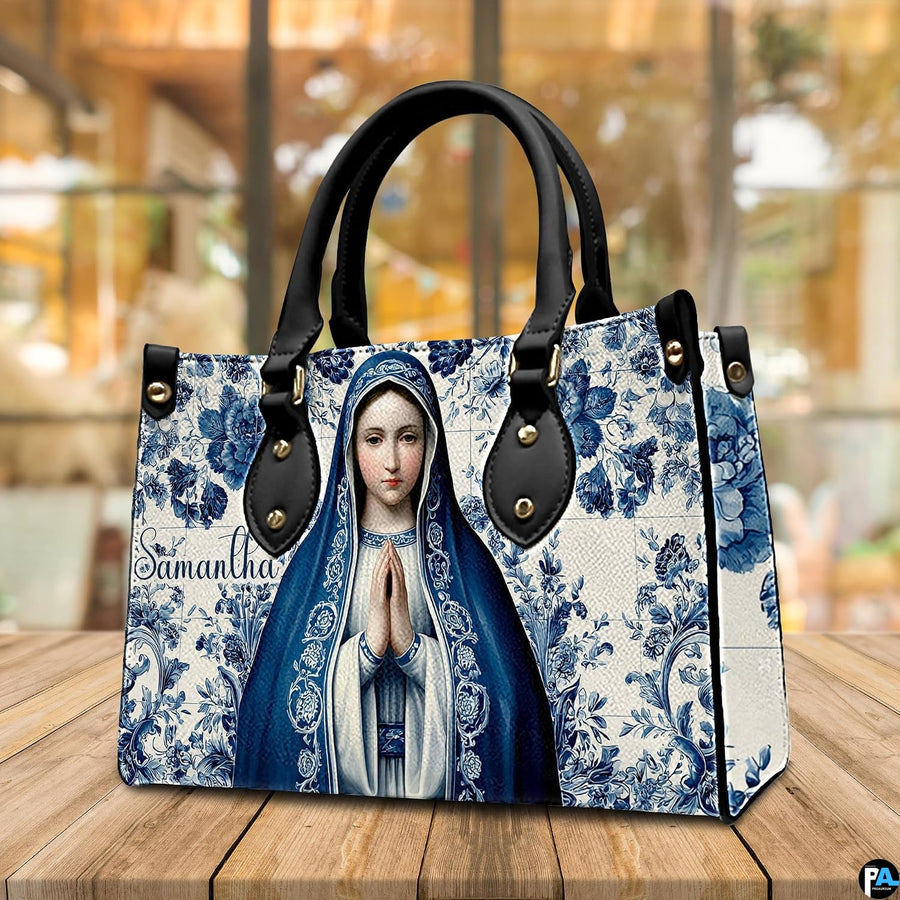 Devotional Virgin Mary ceramic tile handbag presented on wooden tabletop.