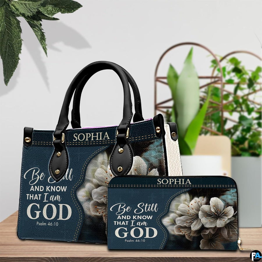 Devotional floral handbag paired with matching wallet on a tabletop near natural indoor greenery.