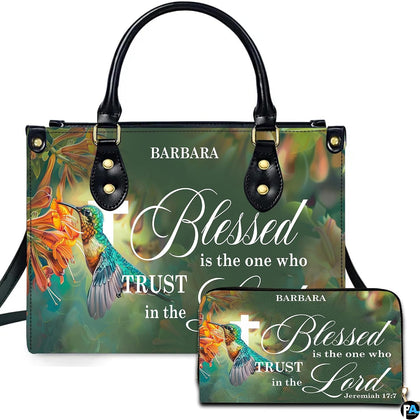 Green hummingbird and cross scripture handbag and matching wallet shown together on neutral studio backdrop.