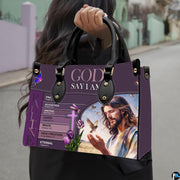 Christian Jesus handbag carried outdoors by top handle on residential street.