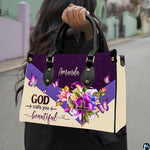 Floral butterfly handbag carried outdoors by top handle on residential street.