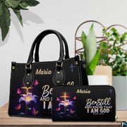 Illuminated cross handbag and coordinating wallet displayed on a wooden table beside potted greenery.