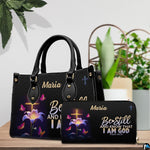Illuminated cross handbag and coordinating wallet displayed on a wooden table beside potted greenery.