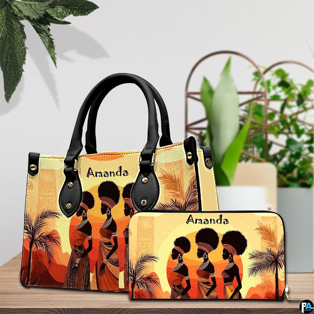 African landscape art prints design arranged on an indoor surface beside green decorative foliage.
