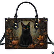 Front studio shot of black cat, glowing jack-o-lanterns, autumn leaves, and vintage lantern.