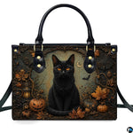 Front studio shot of black cat, glowing jack-o-lanterns, autumn leaves, and vintage lantern.
