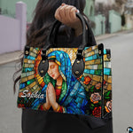 Outdoor lifestyle photo of model holding sacred stained glass design accessory along quiet street.