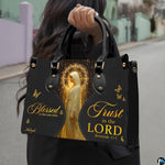 Angled presentation of structured devotional handbag alongside coordinating zippered wallet companion.