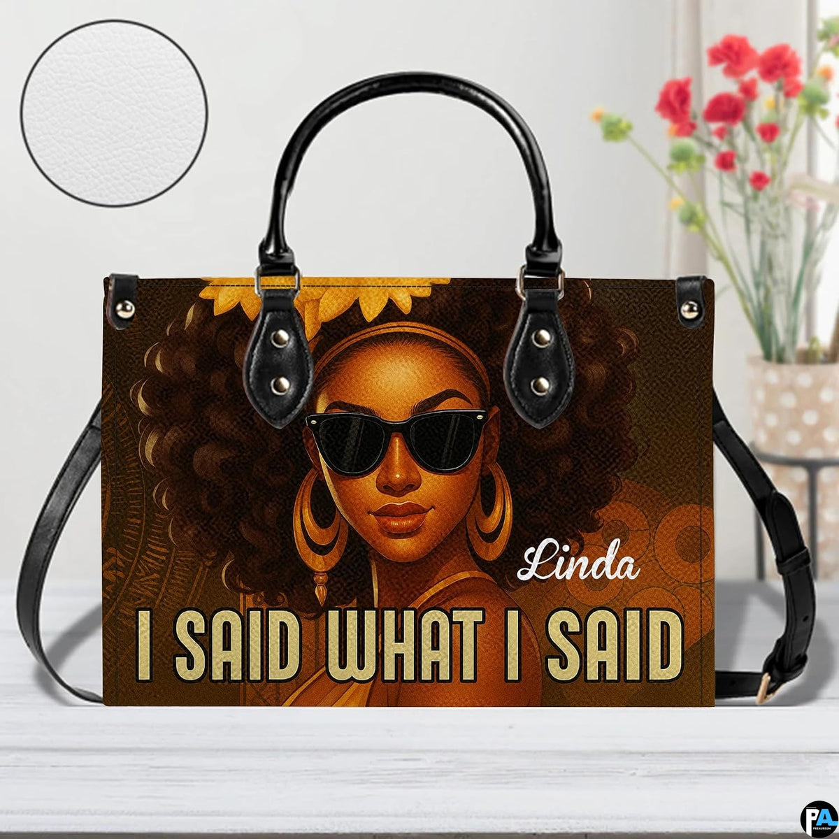 Handbag presented on light tabletop with floral decor and surface texture highlight.