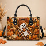 Autumn ghost satchel displayed on tabletop beside white pumpkin and dried decorative pampas grass.