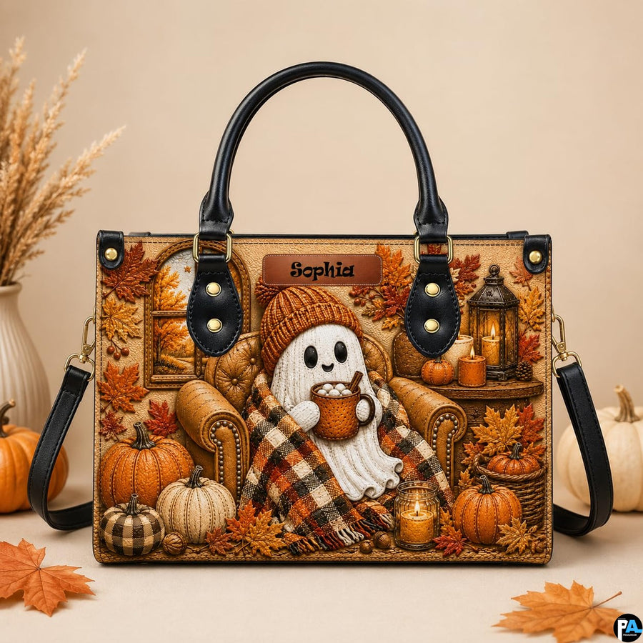 Autumn ghost satchel displayed on tabletop beside white pumpkin and dried decorative pampas grass.