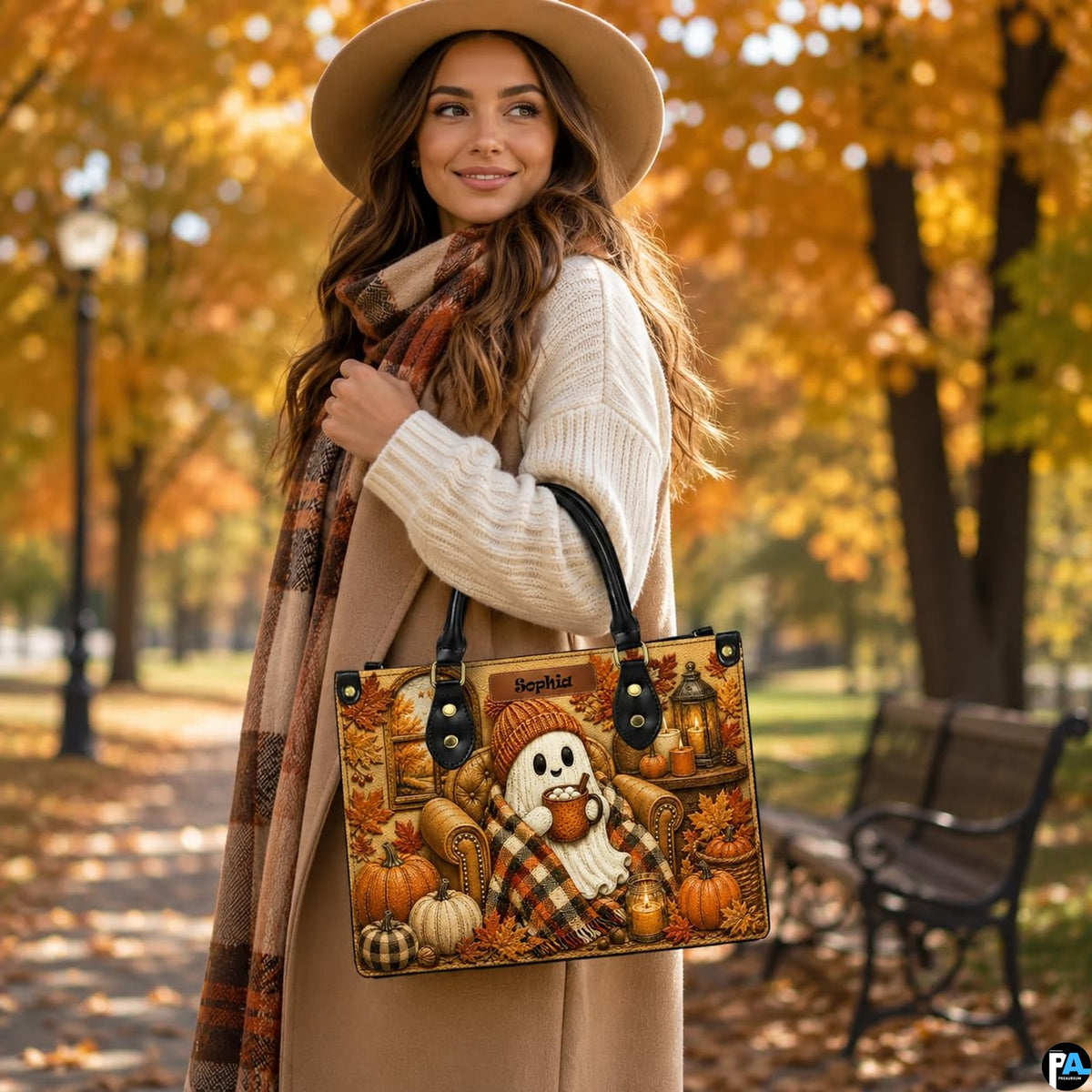 Lifestyle view of model wearing autumn ghost satchel on shoulder in fall park with golden leaves.