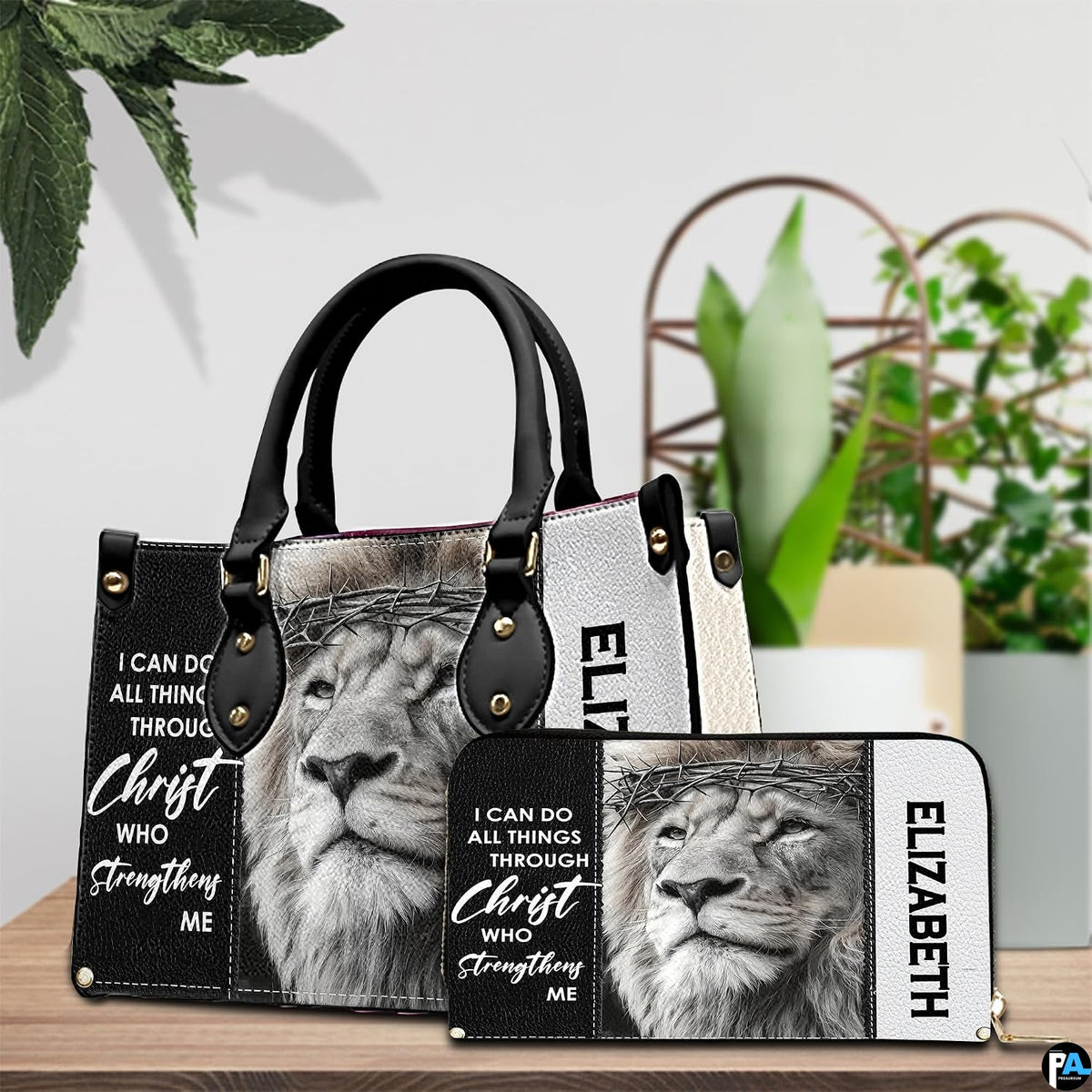 Devotional crowned lion handbag and matching wallet displayed beside decorative greenery.