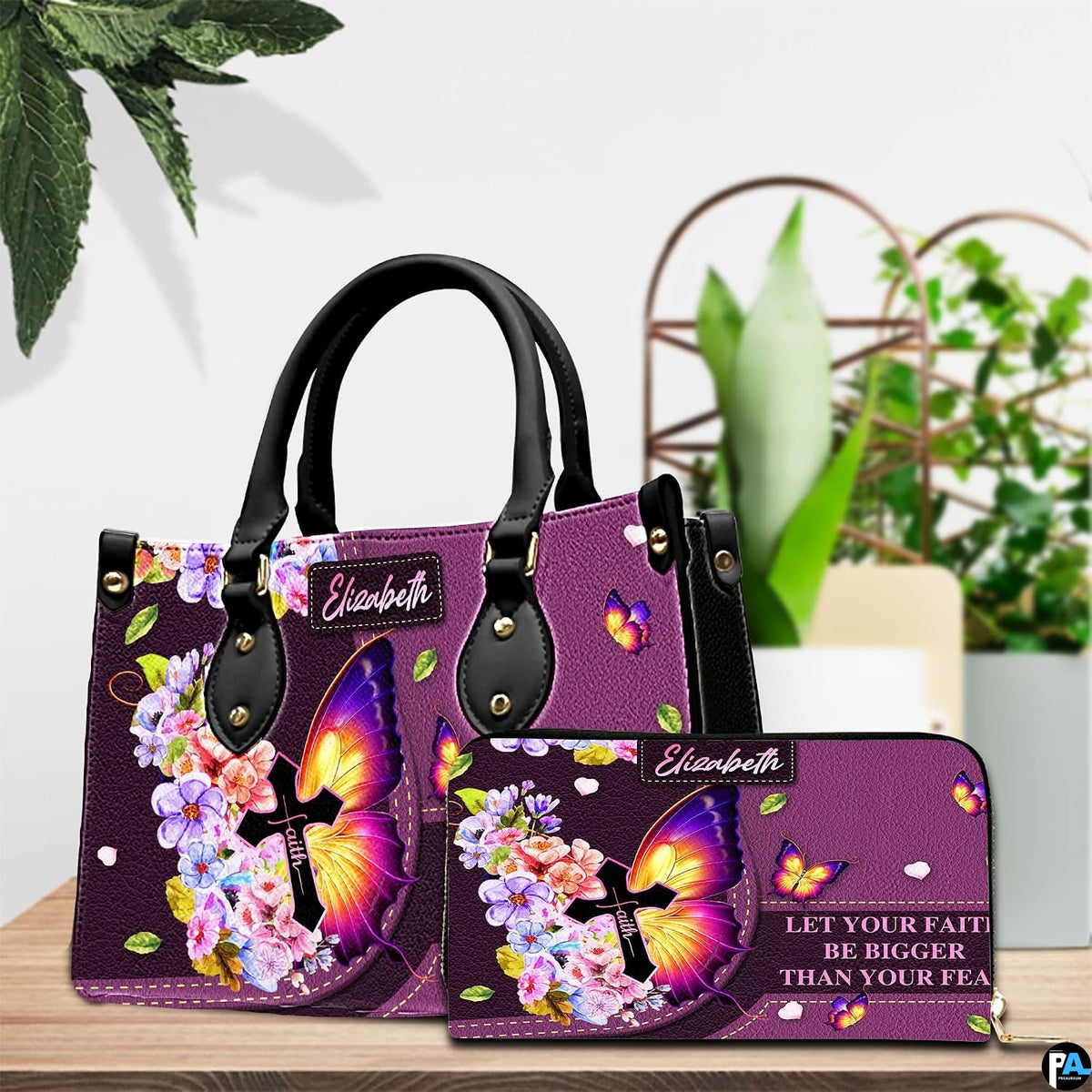 Purple butterfly cross handbag and matching wallet set displayed on wooden table with green plants