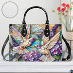 Back view of mosaic hummingbird handbag showing continuous floral pattern on white background.