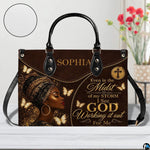 Brown and gold woman portrait handbag with butterfly accents and decorative script styling