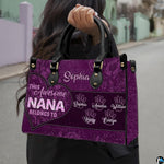 Front view of purple handbag featuring contoured heart outline and rich floral lace patterns.