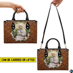 Side profile view of structured tooled Madonna handbag showing silhouette and black handles